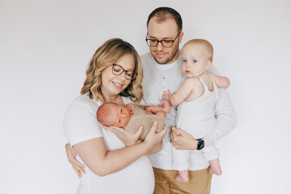 Family portrait with newborn son and toddler son with parents in white and neutrals Columbus Nannies