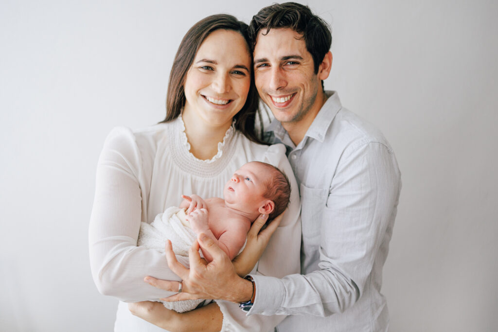mother and father holding newborn son for photoshoot