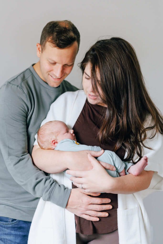 mother and father holding newborn son for photoshoot