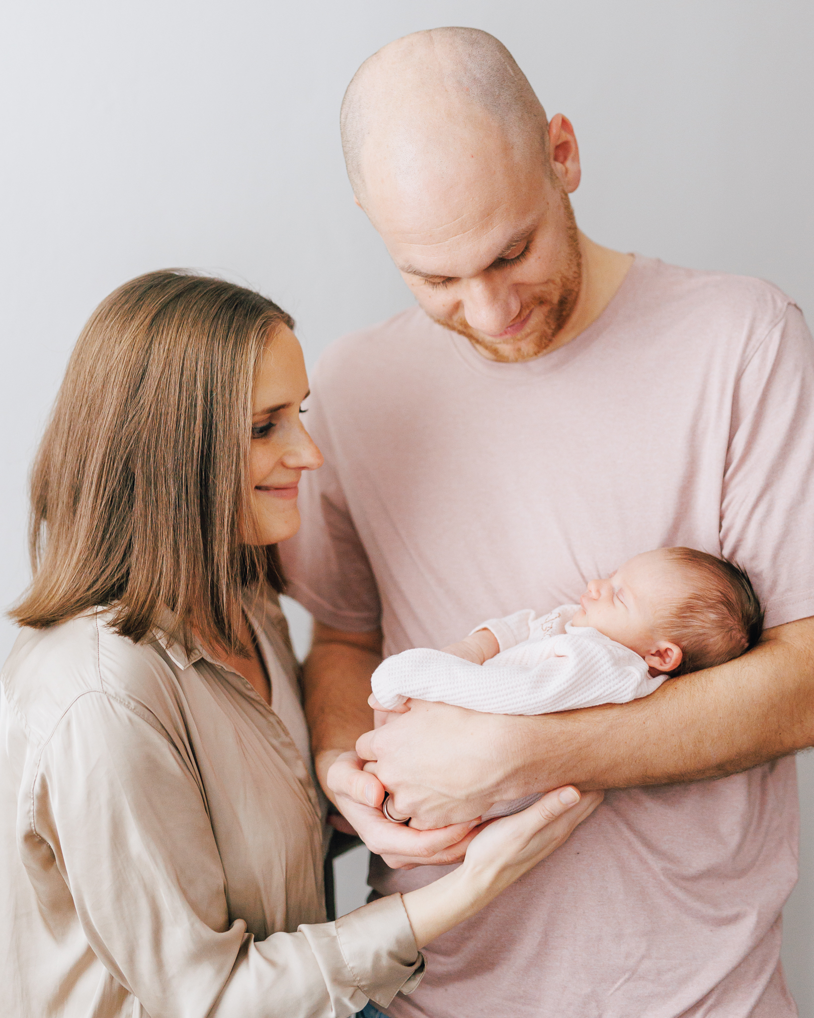 new parents holding newborn for newborn photo session