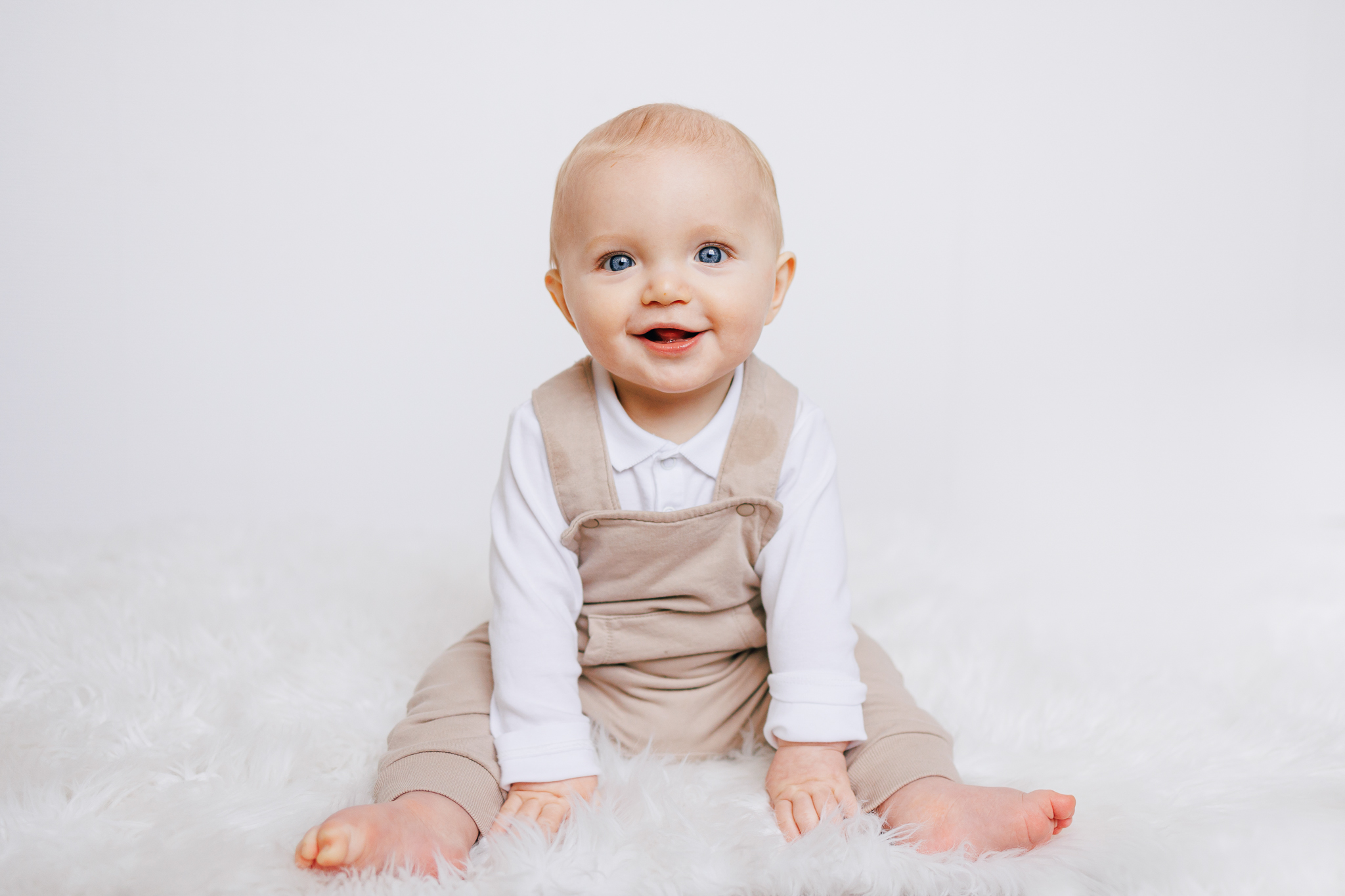 six month old wearing taupe overalls from childrens clothing boutique in columbus ohio