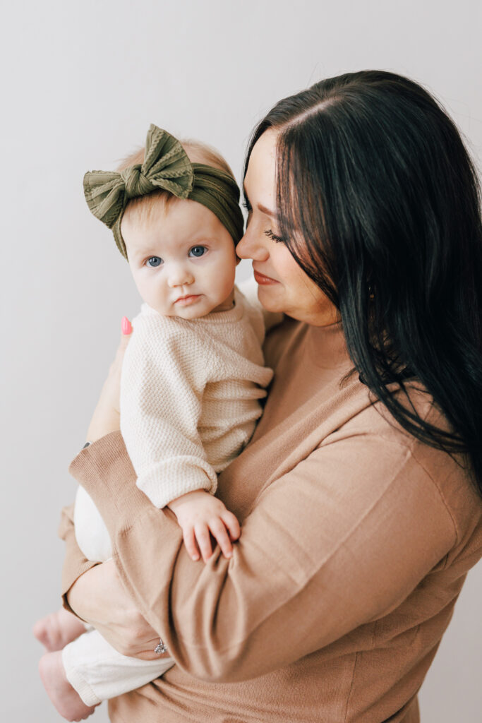 mother snuggling six month old daughter who is looking at the camera columbus daycares