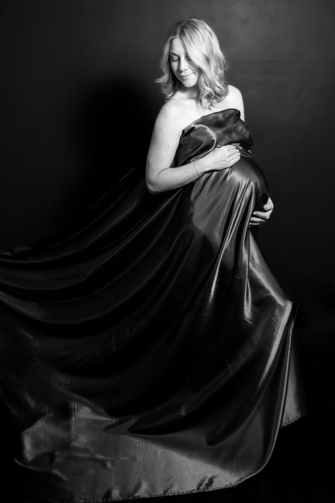 black and white maternity photograph with draping fabric around mother