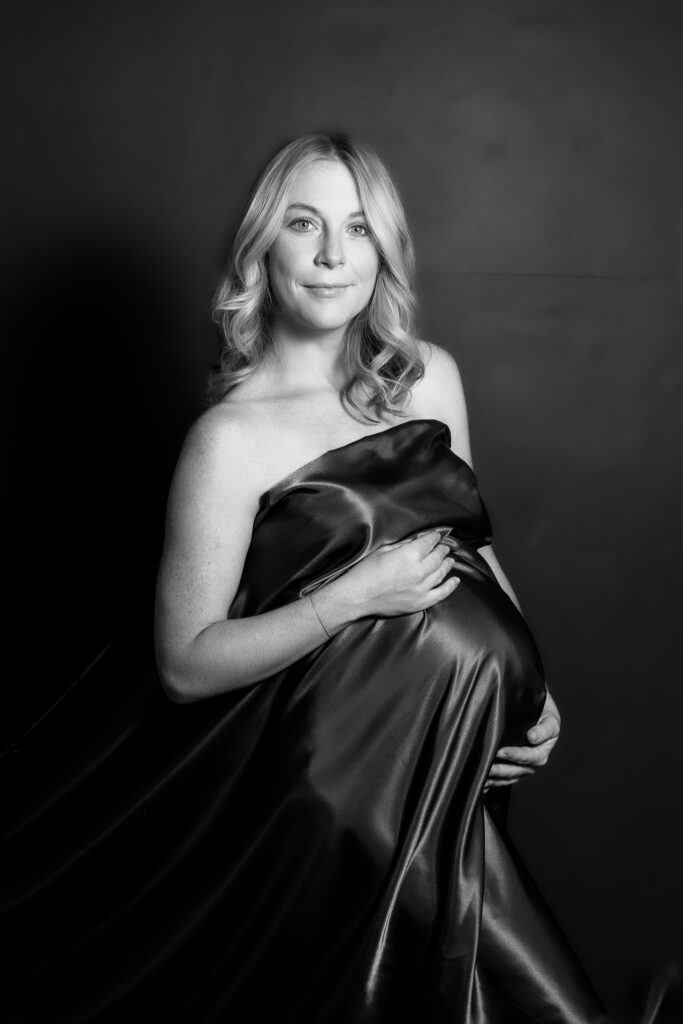 black and white maternity photo shoot with fabric draped around mother
